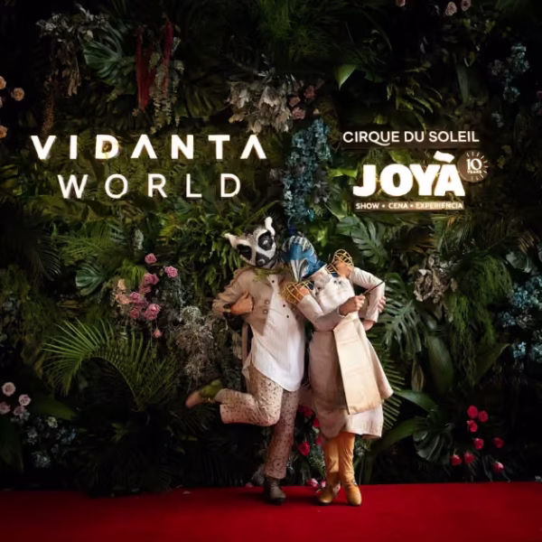 Two performers in animal costumes pose on a red carpet by a flower wall at the Cirque du Soleil JOYÀ 10th Anniversary event.