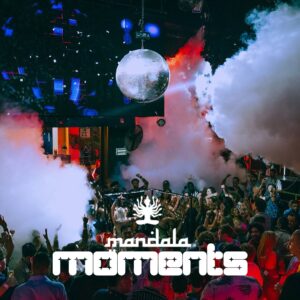 People dancing under a disco ball and colorful lights in a smoky nightclub. “Mandala moments” appears below in bold white text.