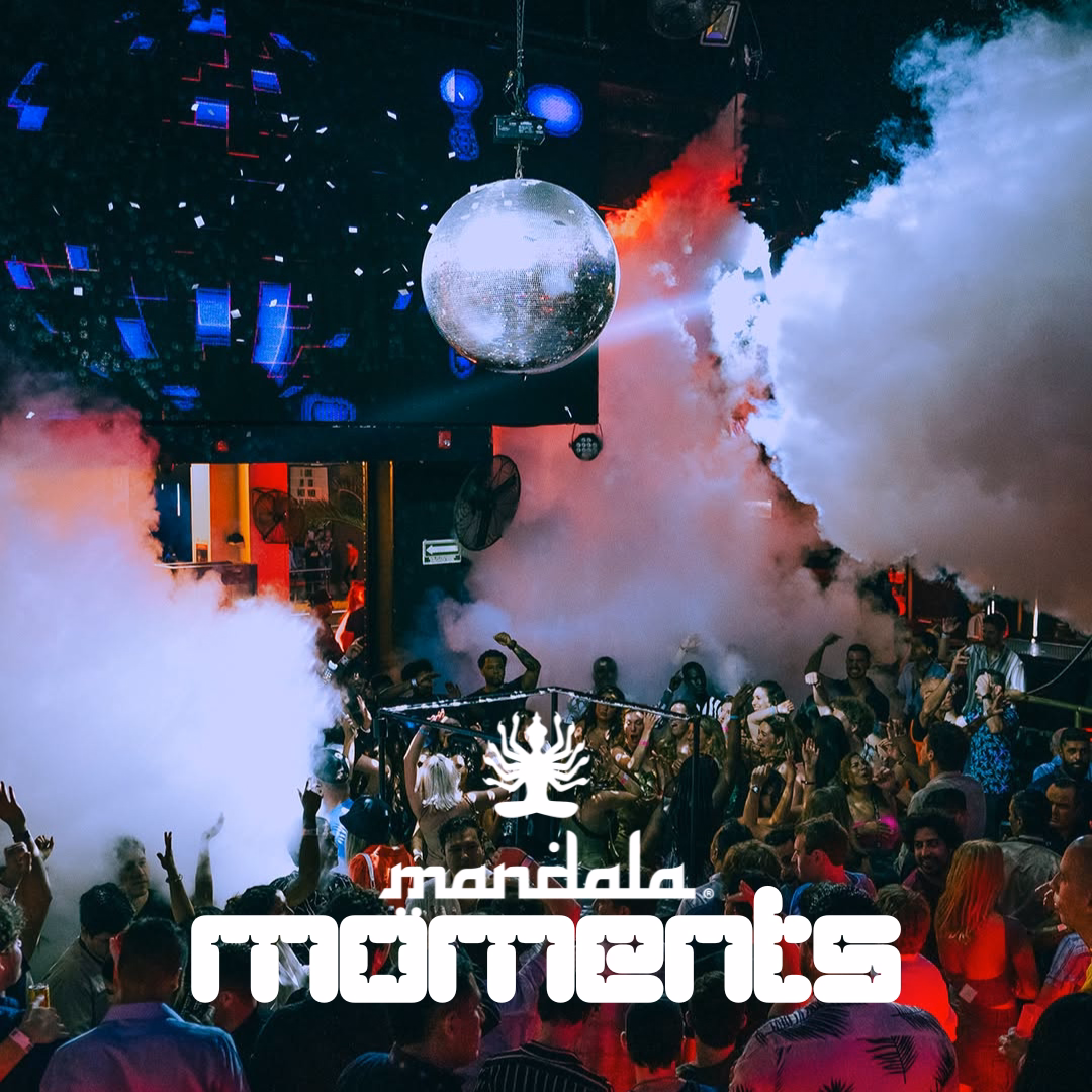 People dancing under a disco ball and colorful lights in a smoky nightclub. āMandala momentsā appears below in bold white text.